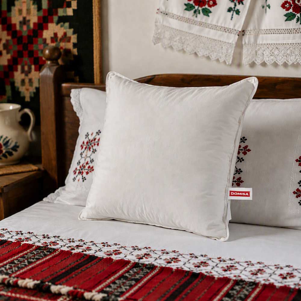 Perna Avira 70x70 cm albă, cu pene de rață, într-un dormitor decorat în stil tradițional românesc