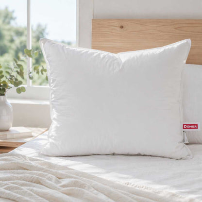 Perna 80x80 din puf de gasca asezata intr-un dormitor alb minimalist