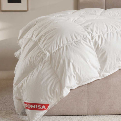 Pilotă albă Ovia 200x220 cm din puf și pene de gâscă, așezată pe pat, cu aspect pufos și confortabil.