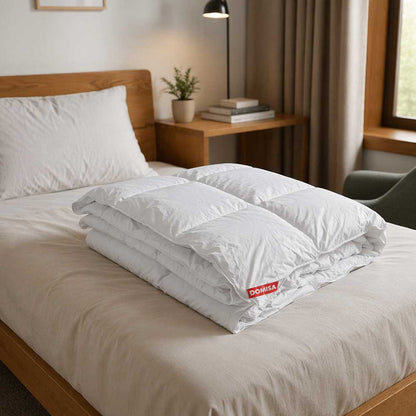 Pilotă Ovia albă 140x200 cm umplută cu 15% puf și 85% pene de gâscă, prezentată împătурită elegant