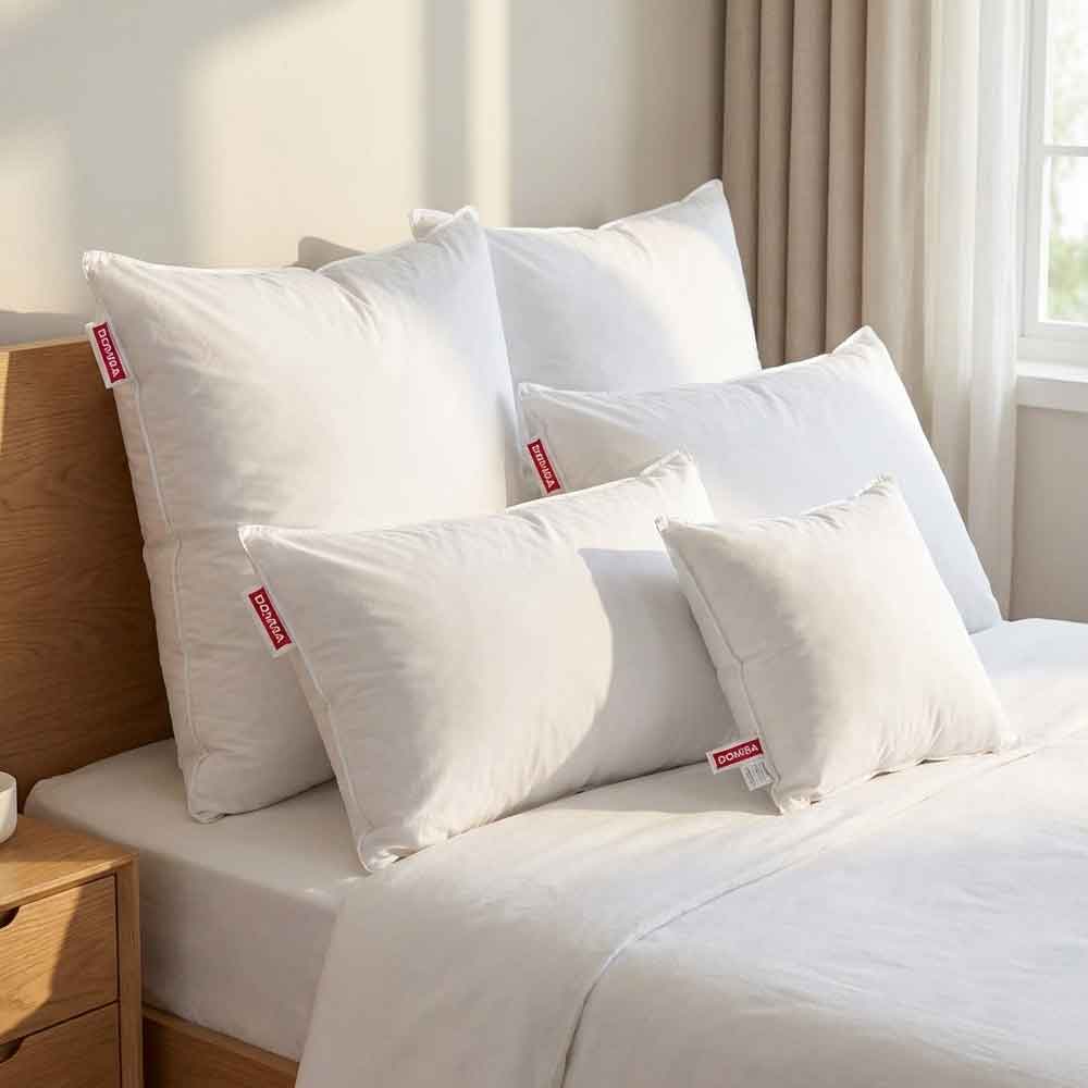 Toate dimensiunile de perne Ovia cu pene de gasca asezate pe pat, 40x40, 40x60, 50x70, 70x70