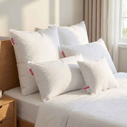 Toate dimensiunile de perne Ovia cu pene de gasca asezate pe pat, 40x40, 40x60, 50x70, 70x70